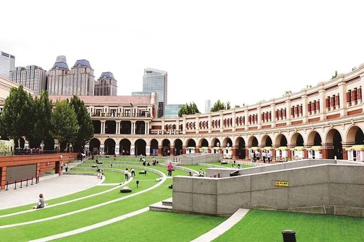 a large building with a courtyard with green grass