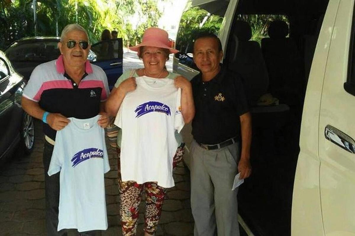 two men and a woman standing next to a van