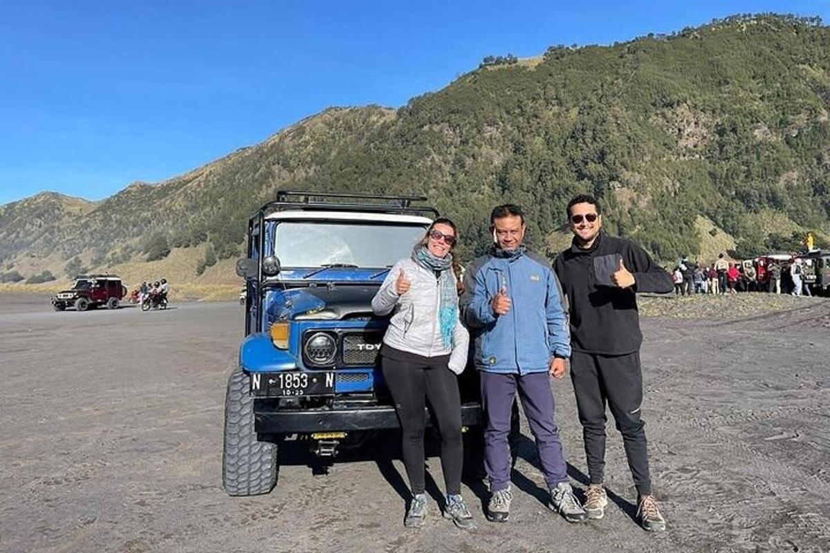 a group of three people standing next to a truck