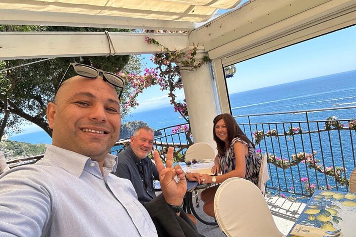 un gruppo di persone sedute a un tavolo su un balcone