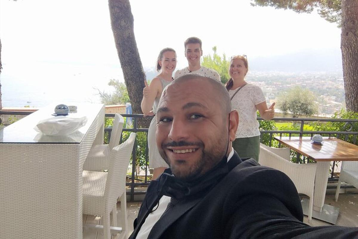 muž s motýlkem a skupina lidí