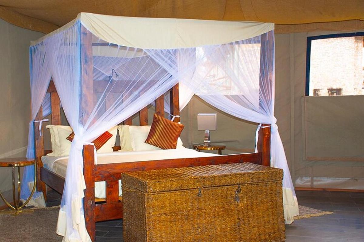 une chambre avec un lit à baldaquin avec un coffre