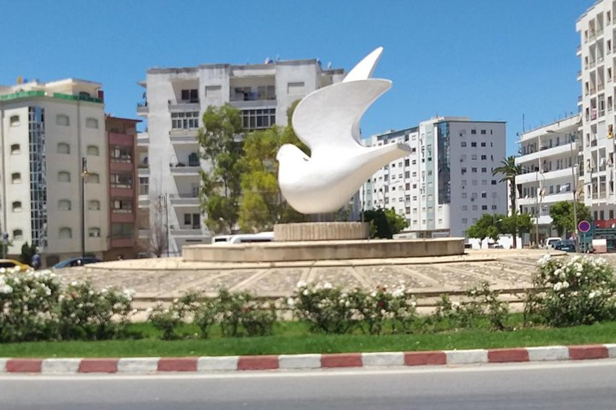eine große weiße Vogelstatue mitten in einer Stadt