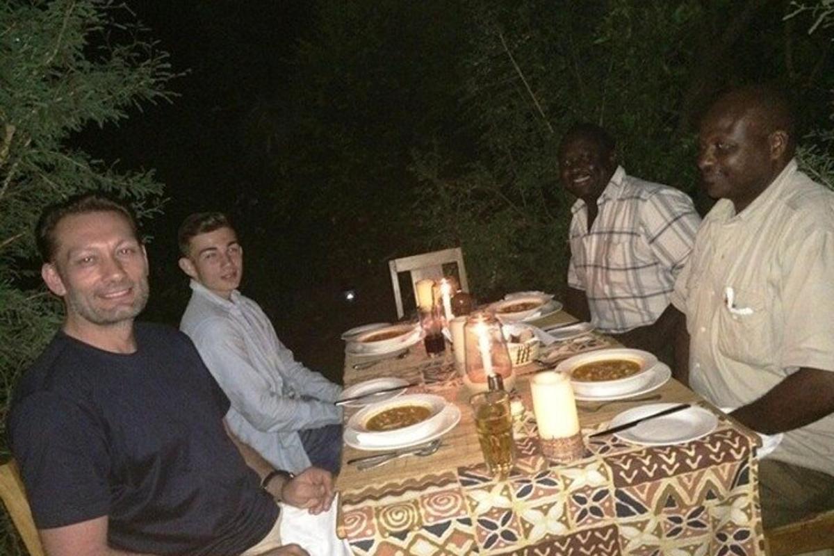 um grupo de homens sentados ao redor de uma mesa com comida