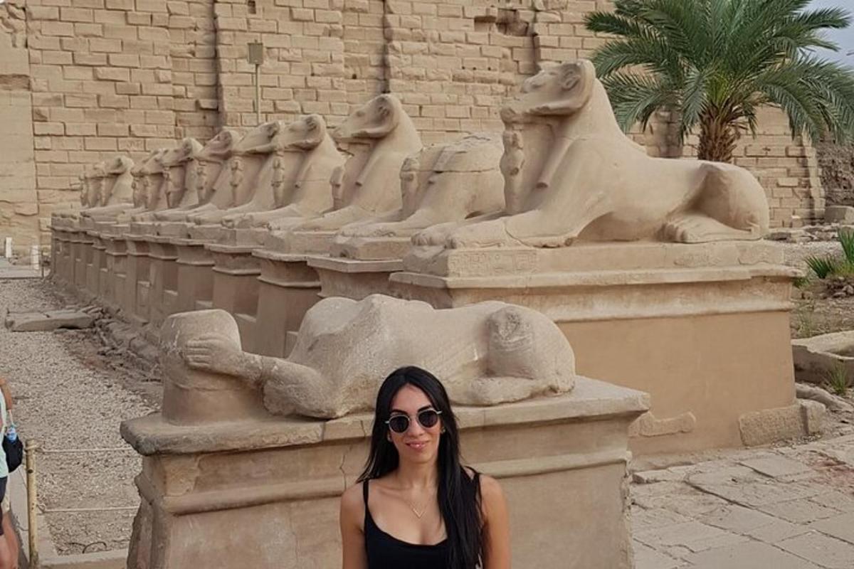Una mujer está parada frente a una estatua