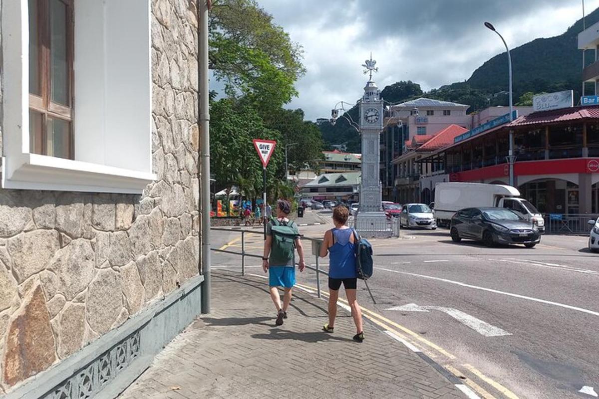 two people walking down a sidewalk on a city street