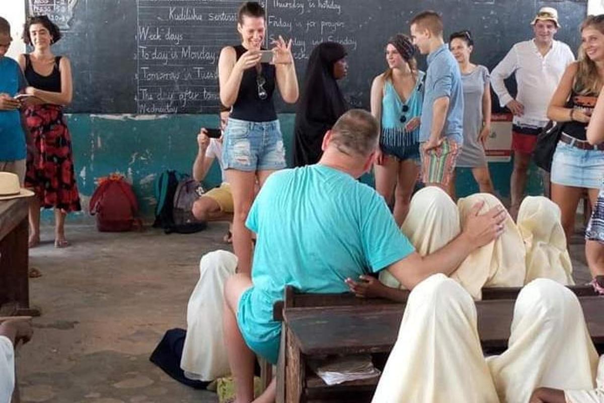 un grup de oameni așezați pe o bancă într-o sală de clasă