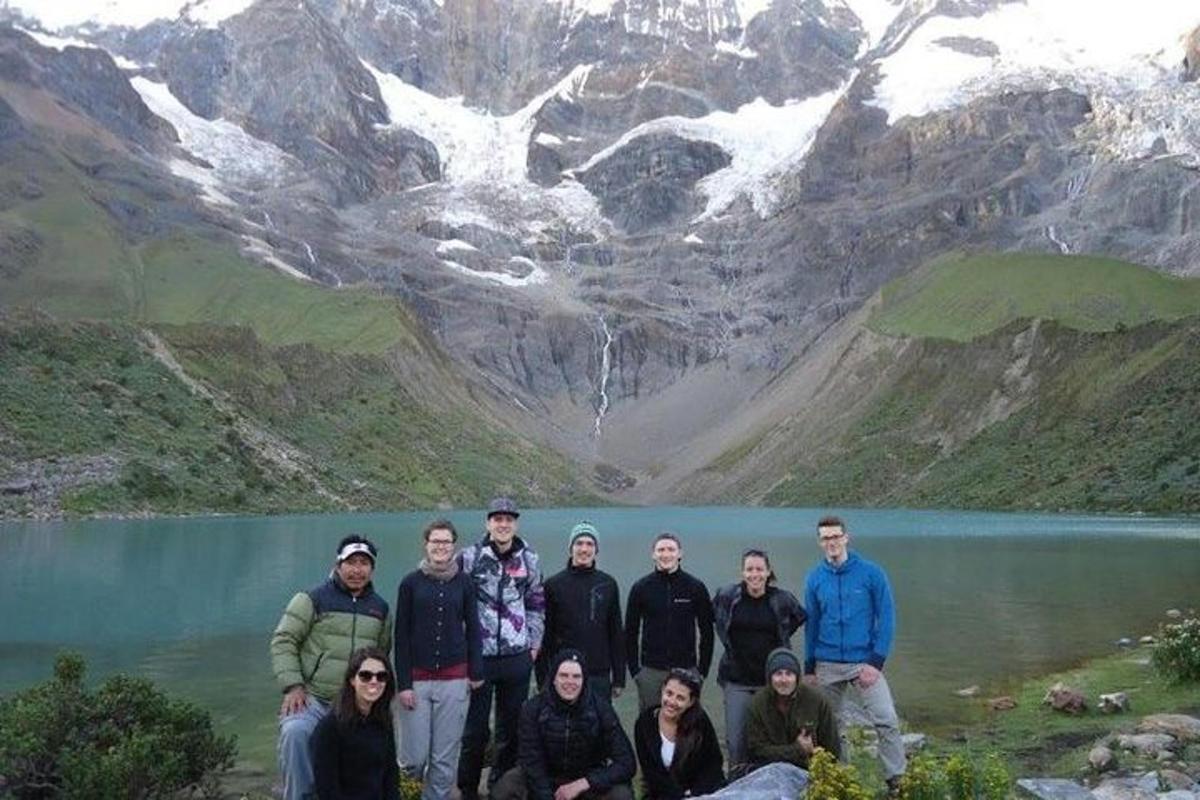 Un grupo de personas de pie frente a un lago
