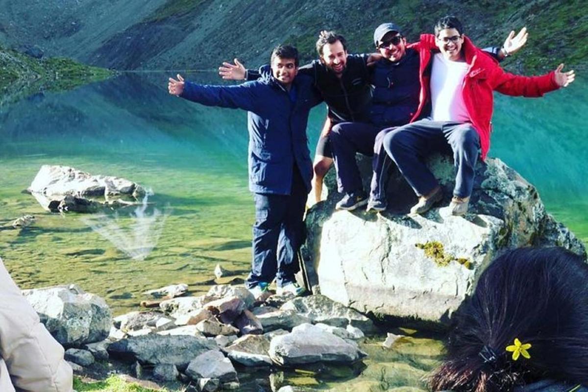 Un grupo de personas sentadas en una roca cerca del agua.