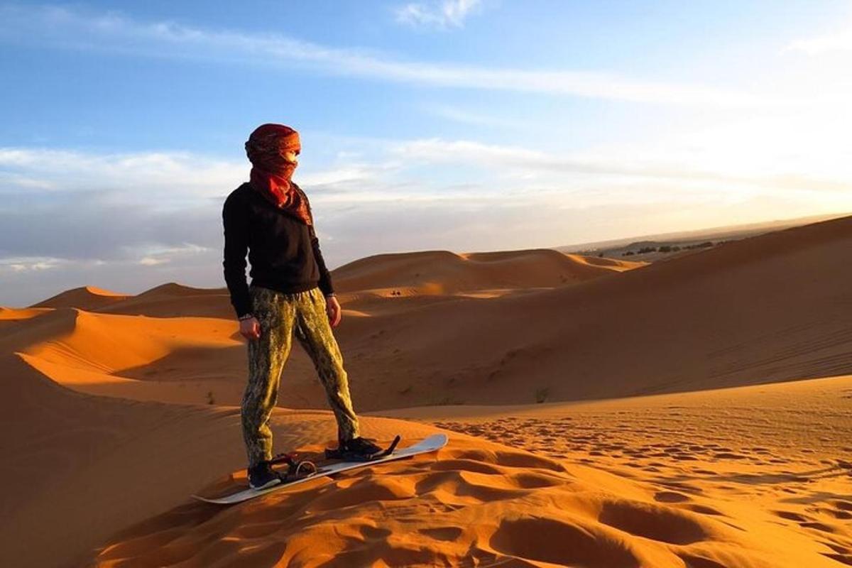 Un hombre parado en una tabla de snowboard en el desierto
