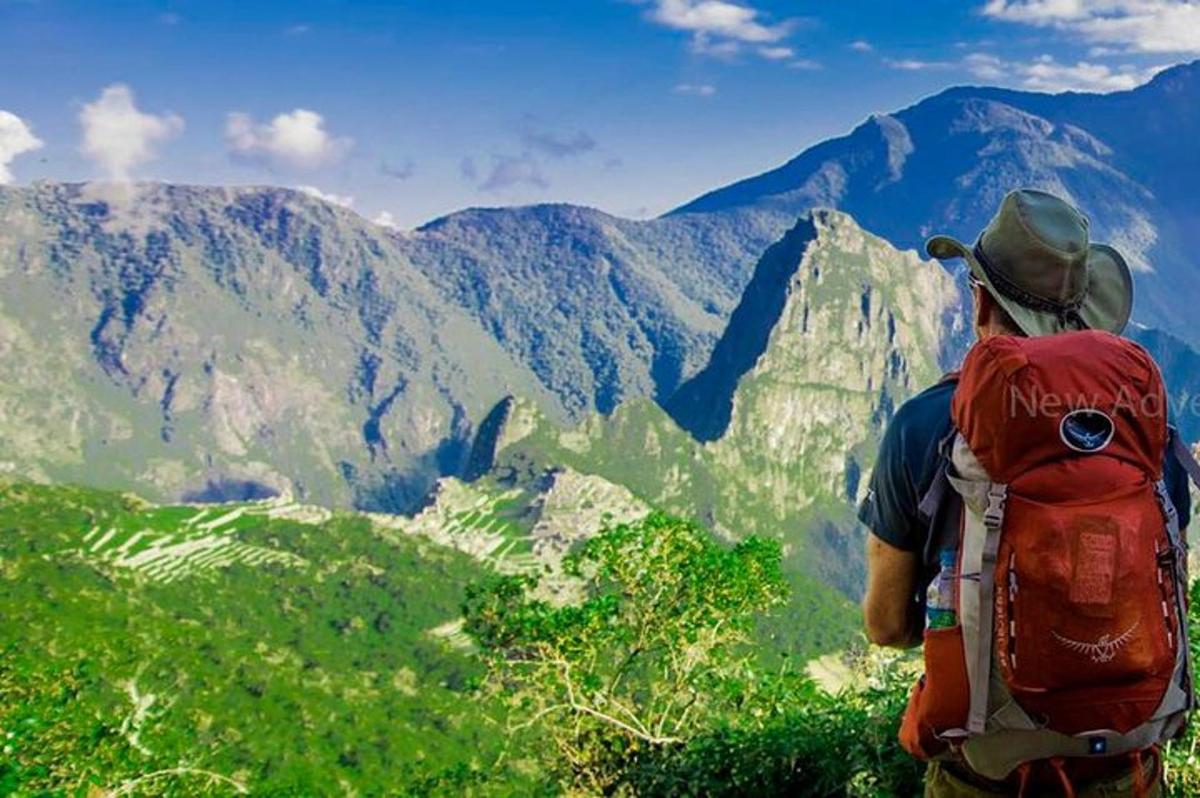 un homme avec un sac à dos debout au sommet d'une montagne