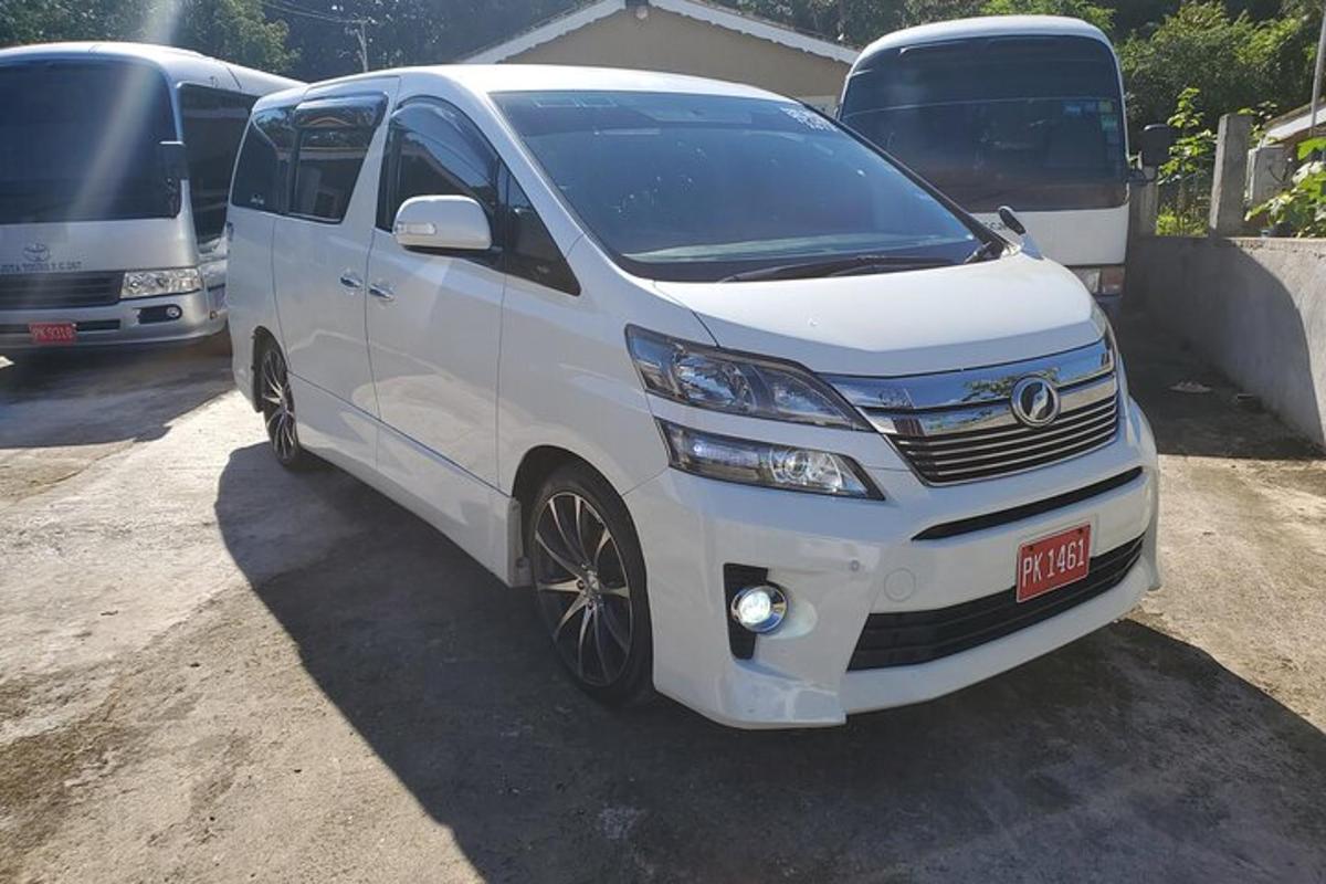 sebuah van putih berhenti di hadapan dua buah bas