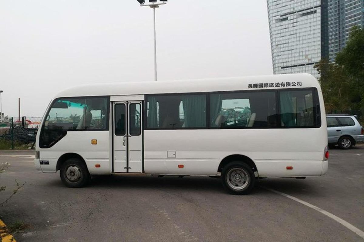 bílý autobus zaparkovaný na parkovišti