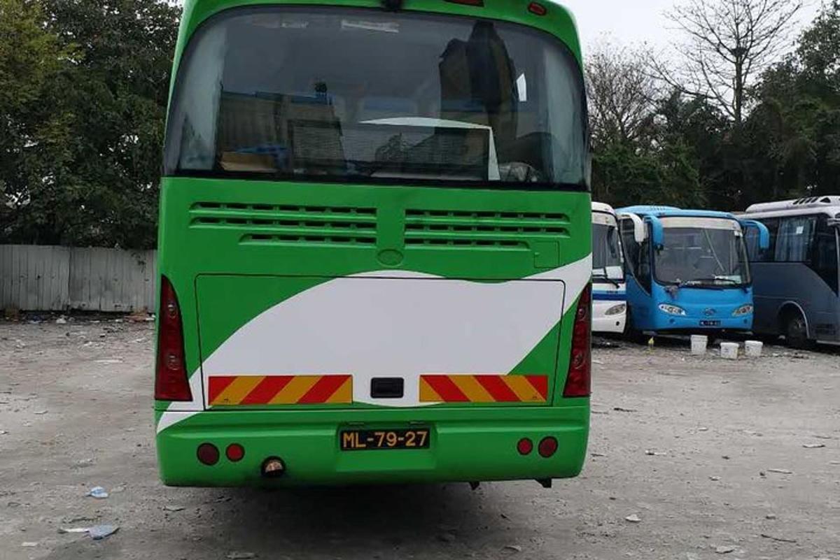 a green and white bus parked in a parking lot