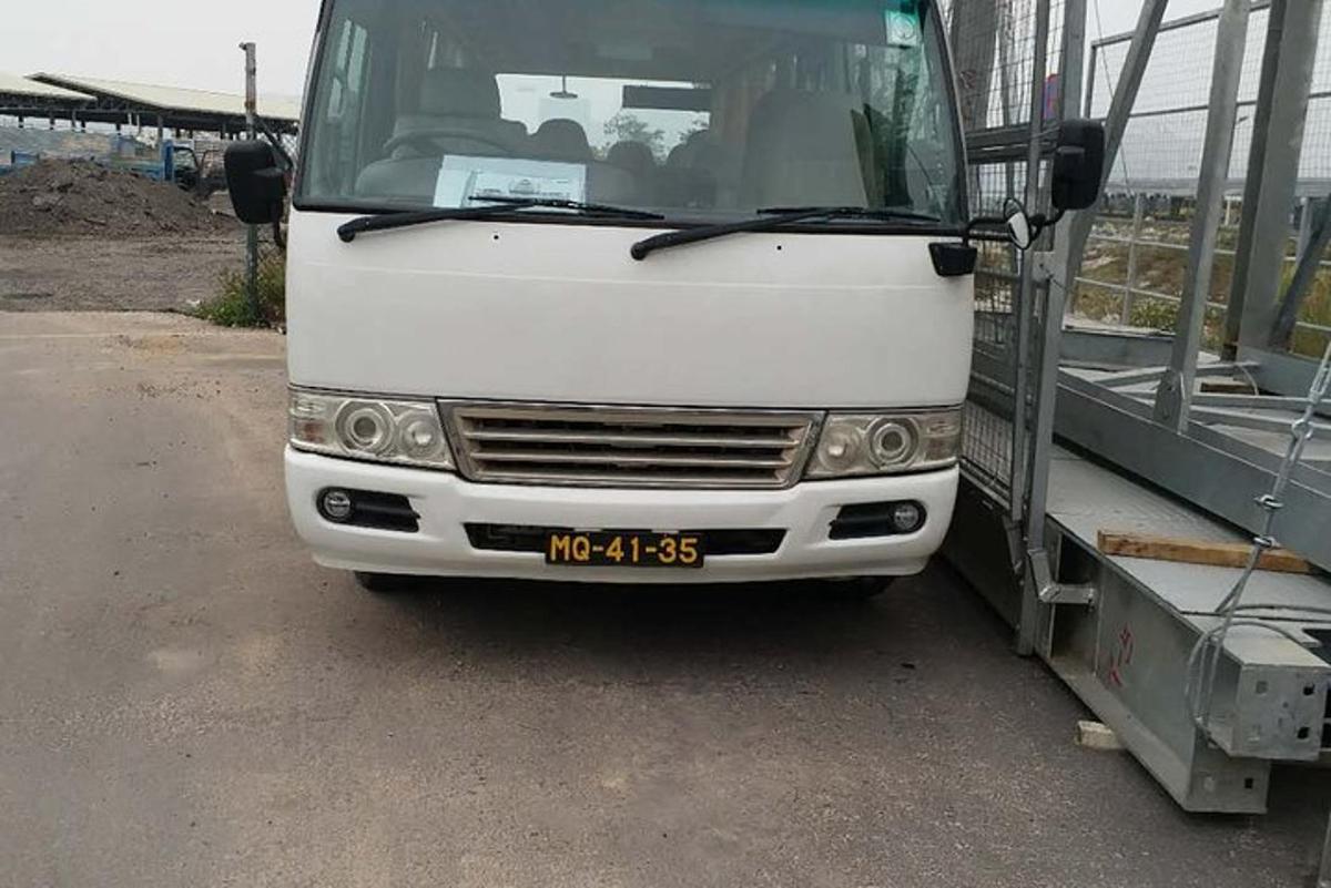 a white bus is parked next to a truck