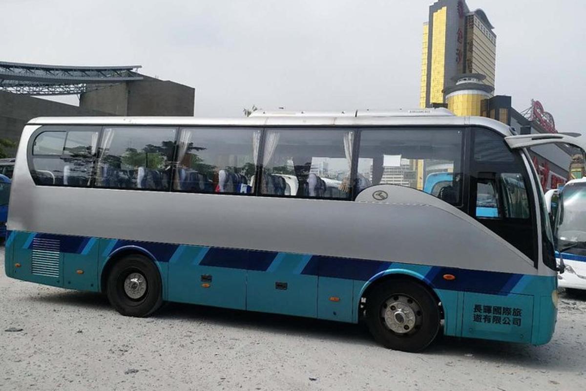 a blue and white bus parked in a parking lot