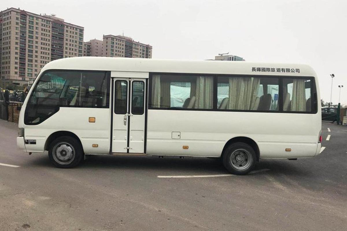bílý autobus zaparkovaný na parkovišti
