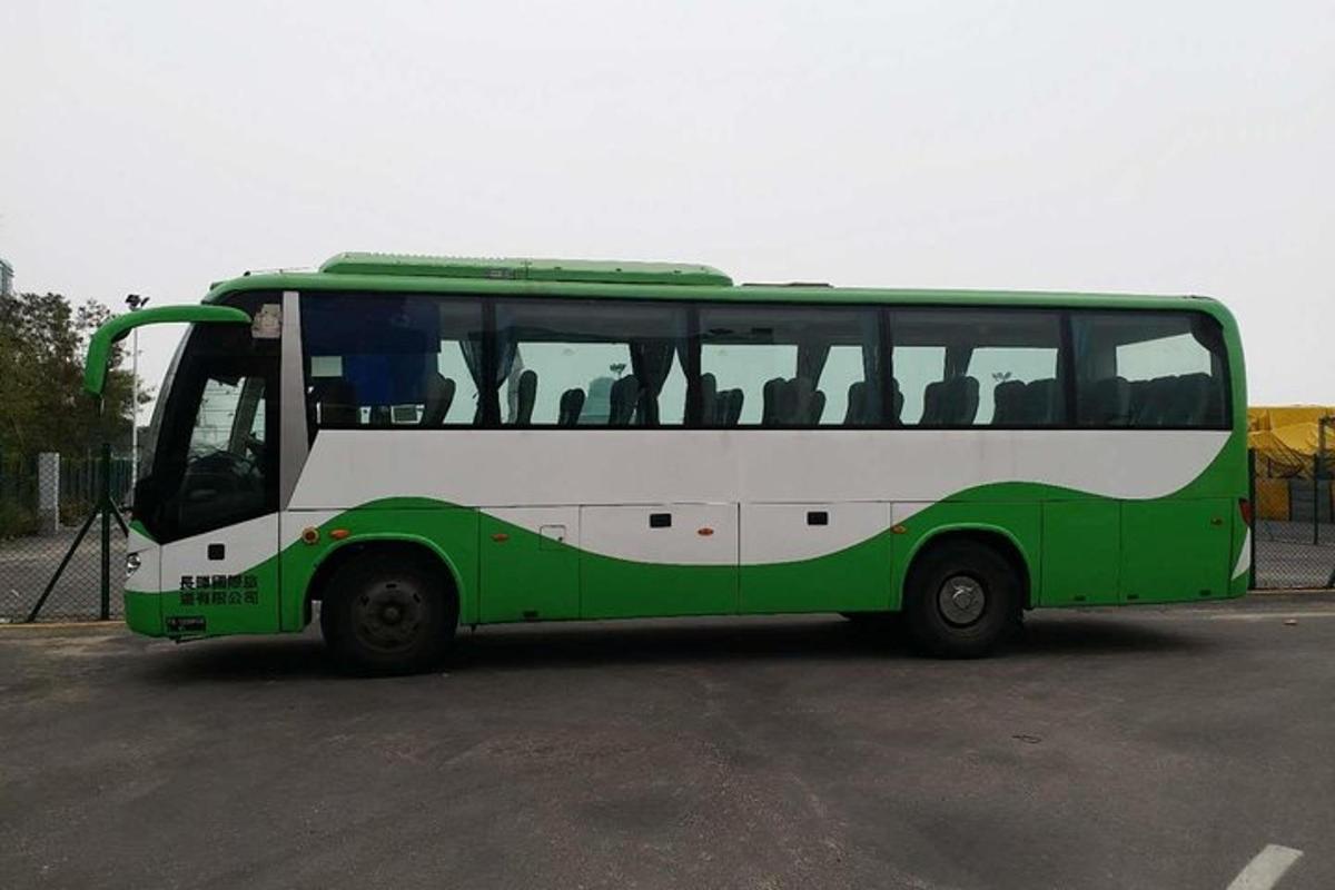 a green and white bus parked in a parking lot