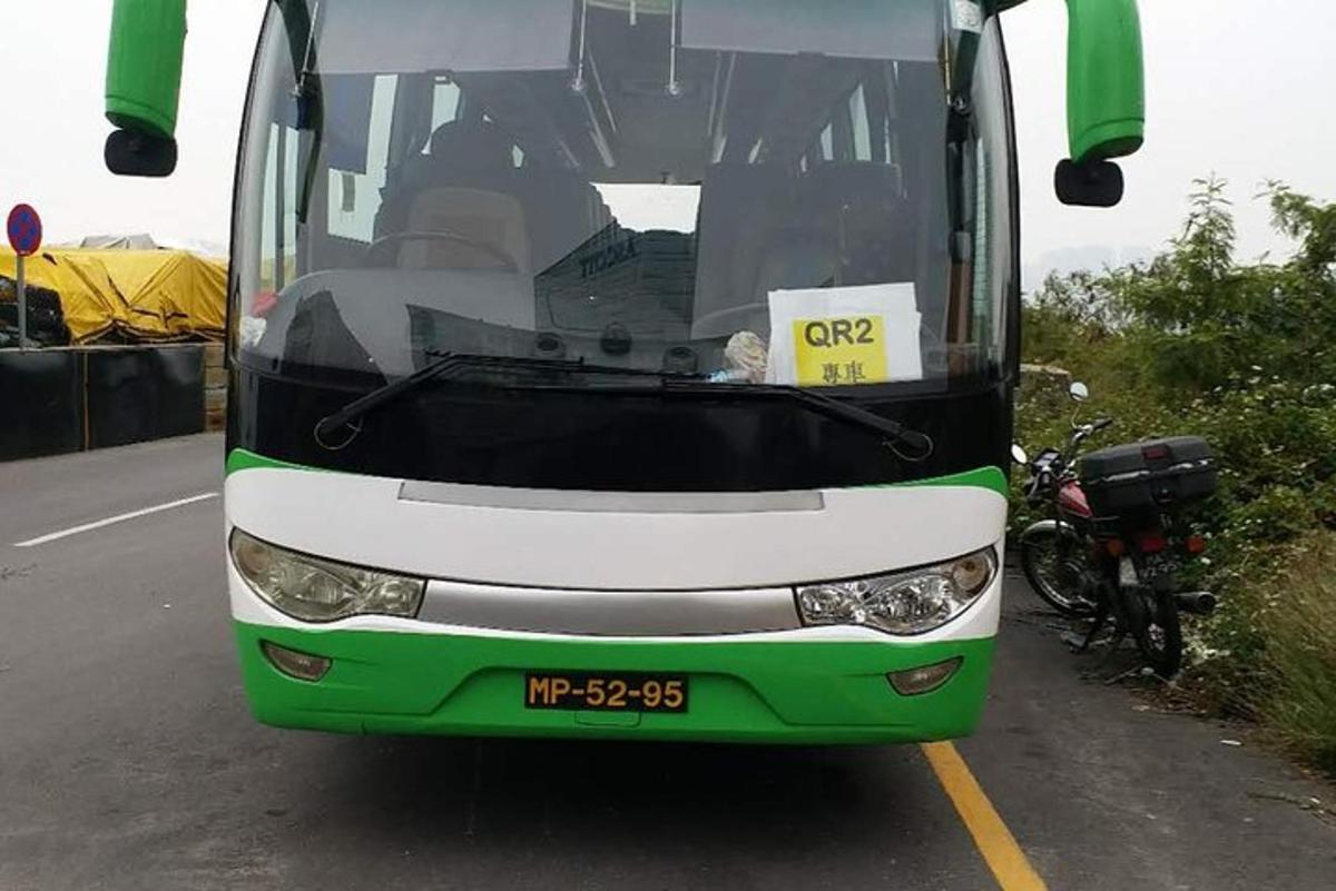 a green and white bus with a sign in the front