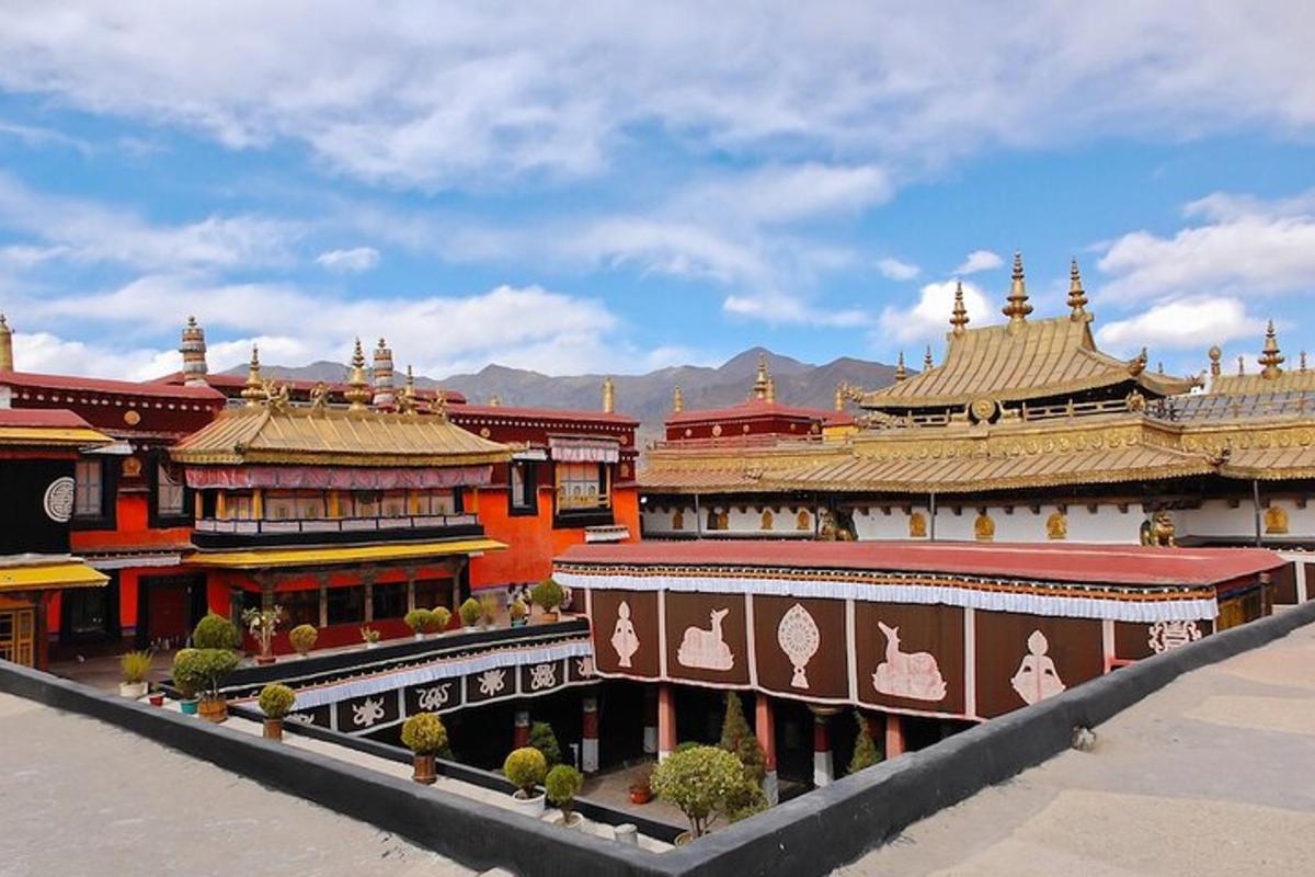 a group of buildings in a city with mountains in the background