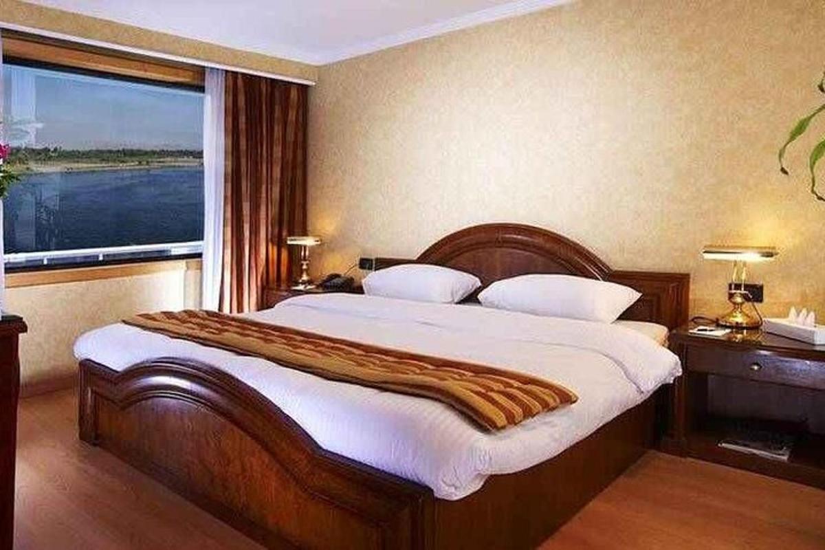 una camera da letto con un letto grande con una grande finestra