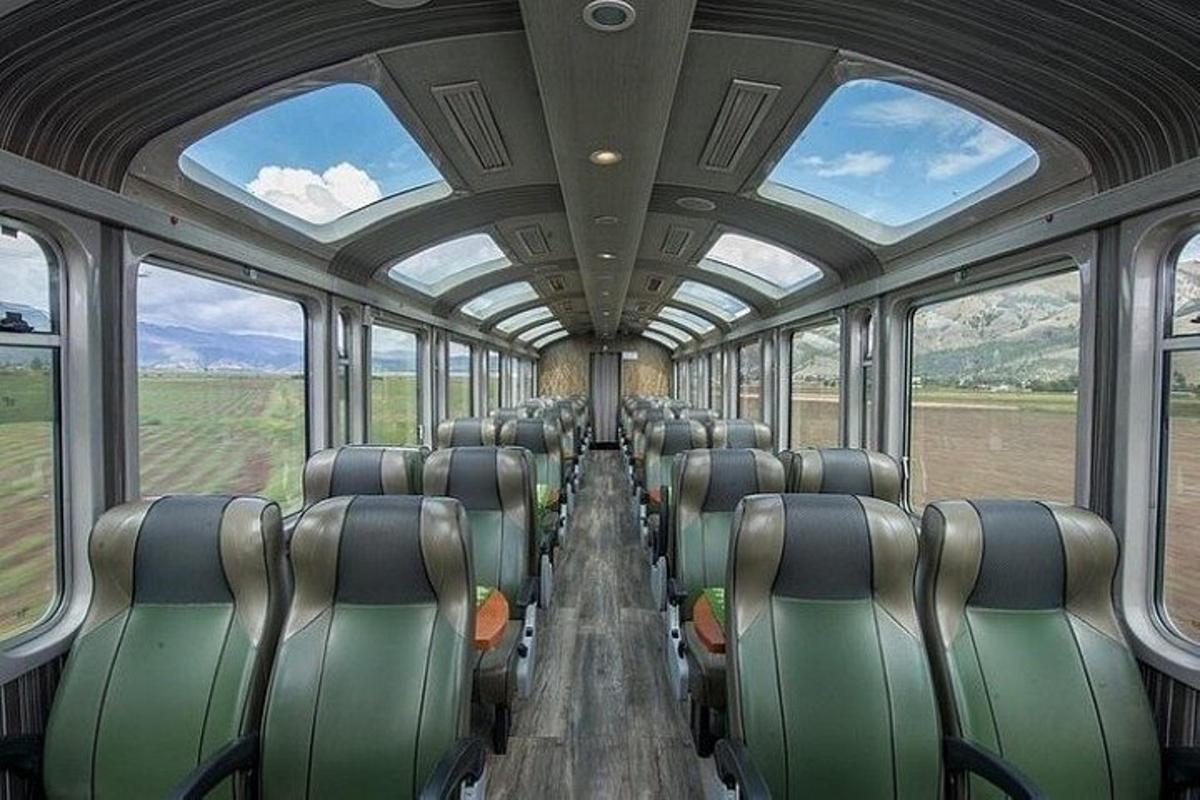 Un vagón de tren vacío con asientos vacíos en el medio.