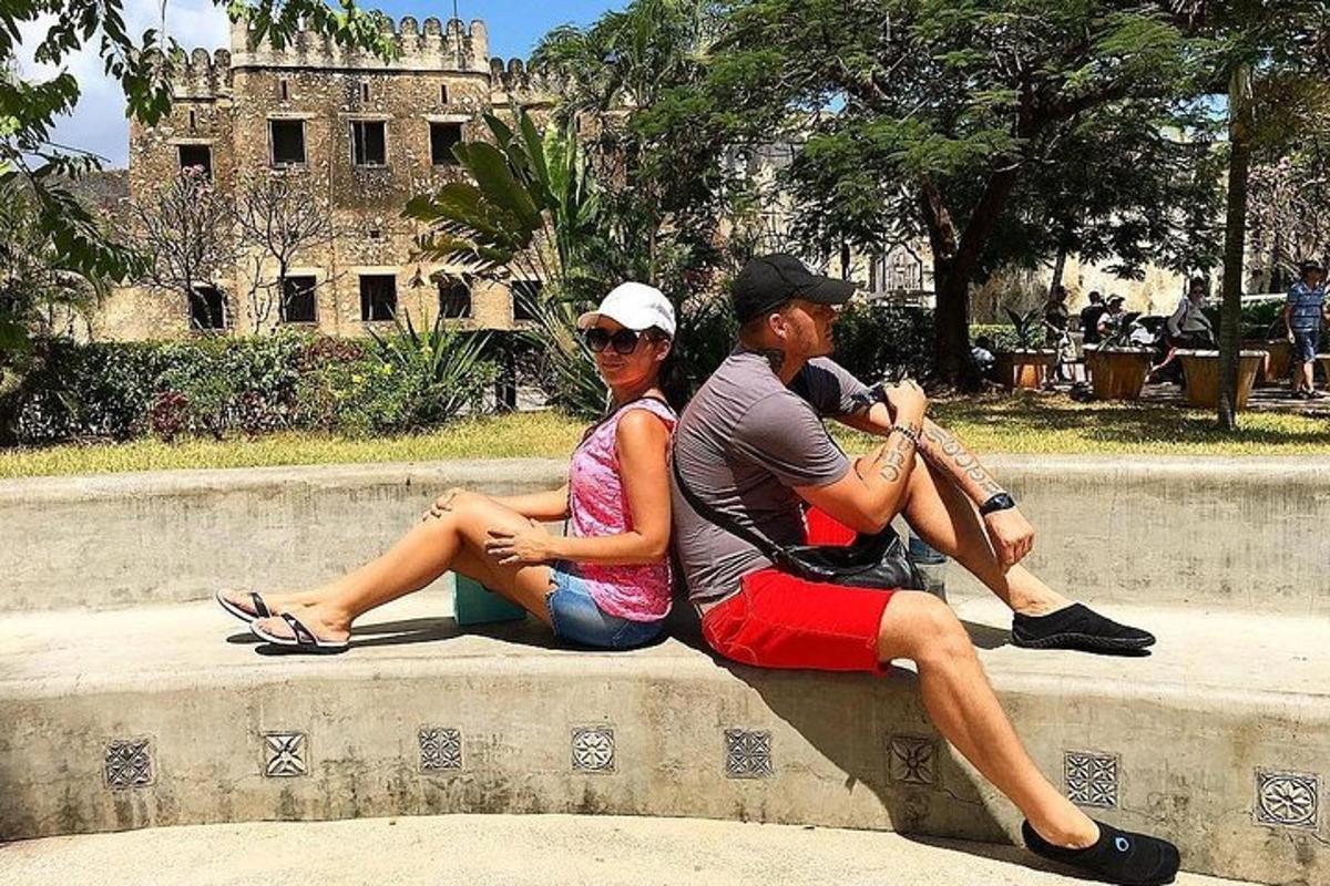 dues persones assegudes en una paret davant d'un castell