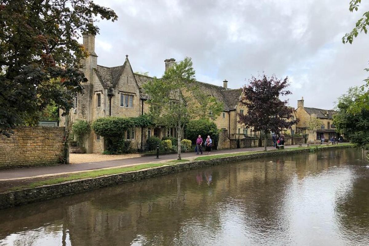 a building next to a river with people walking by it