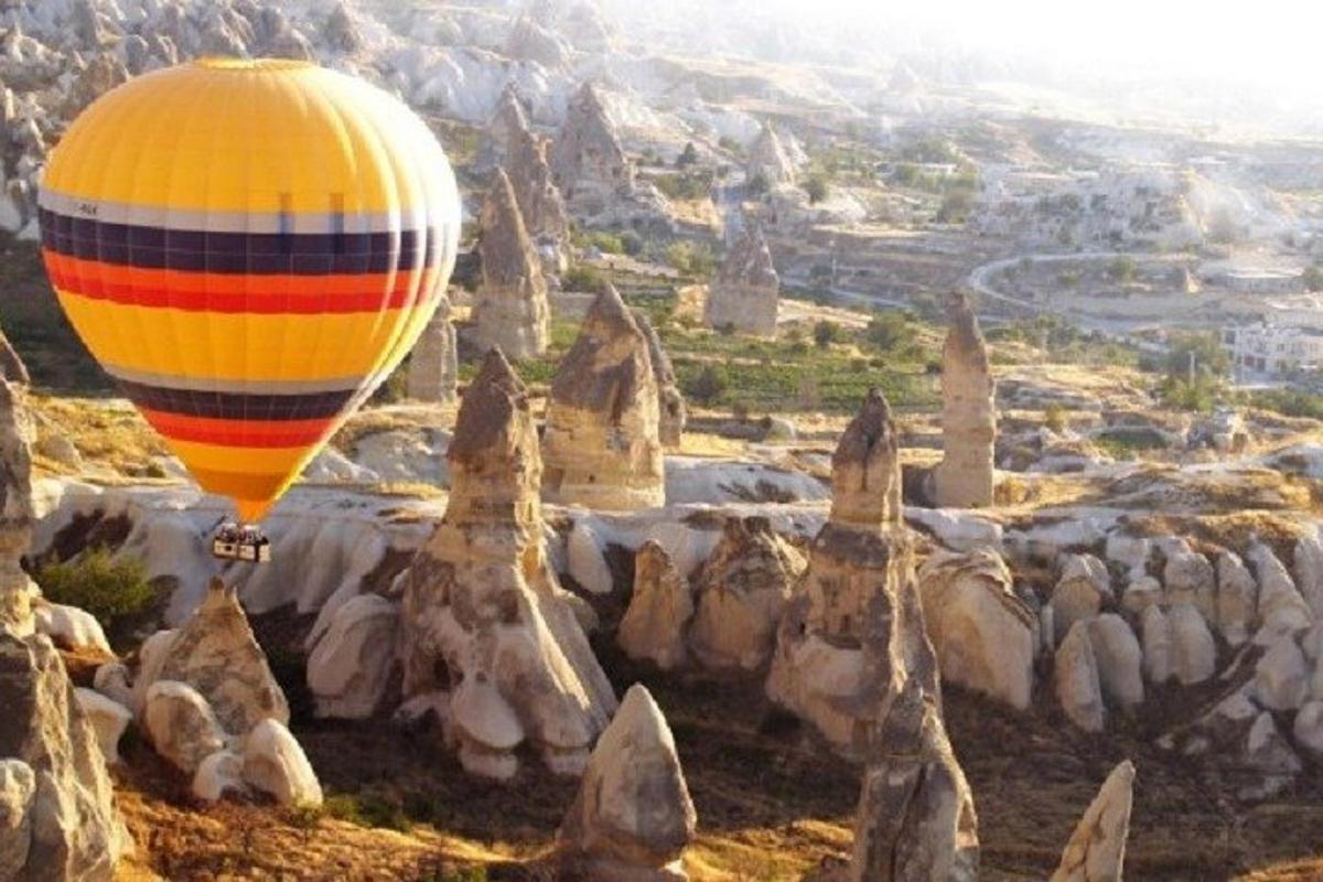 isang hot air balloon na lumilipad sa ibabaw ng mga rock formation