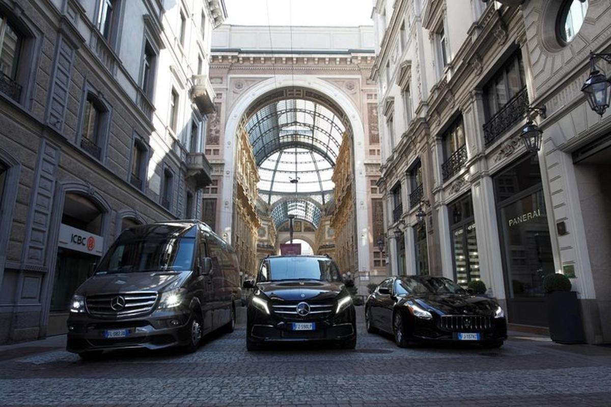 two cars and a van parked in a street