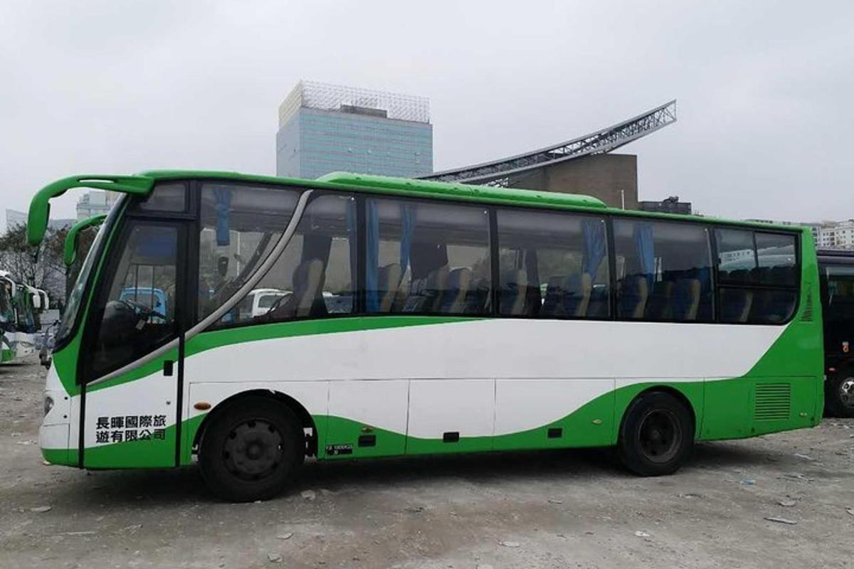 um ônibus verde e branco estacionado em um estacionamento
