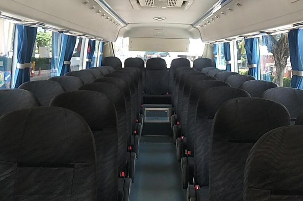 ein leerer Bus mit schwarzen Sitzen in einem Bus