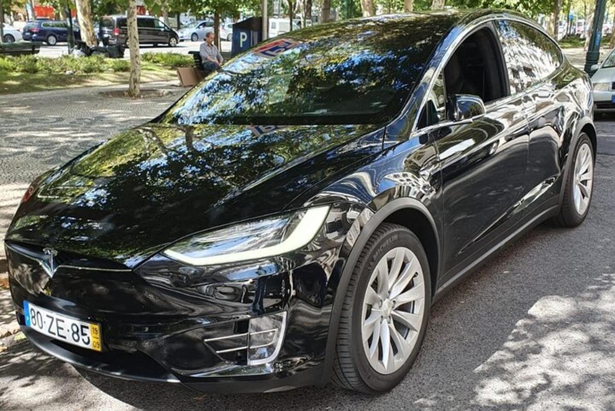 un'auto nera parcheggiata sul ciglio di una strada