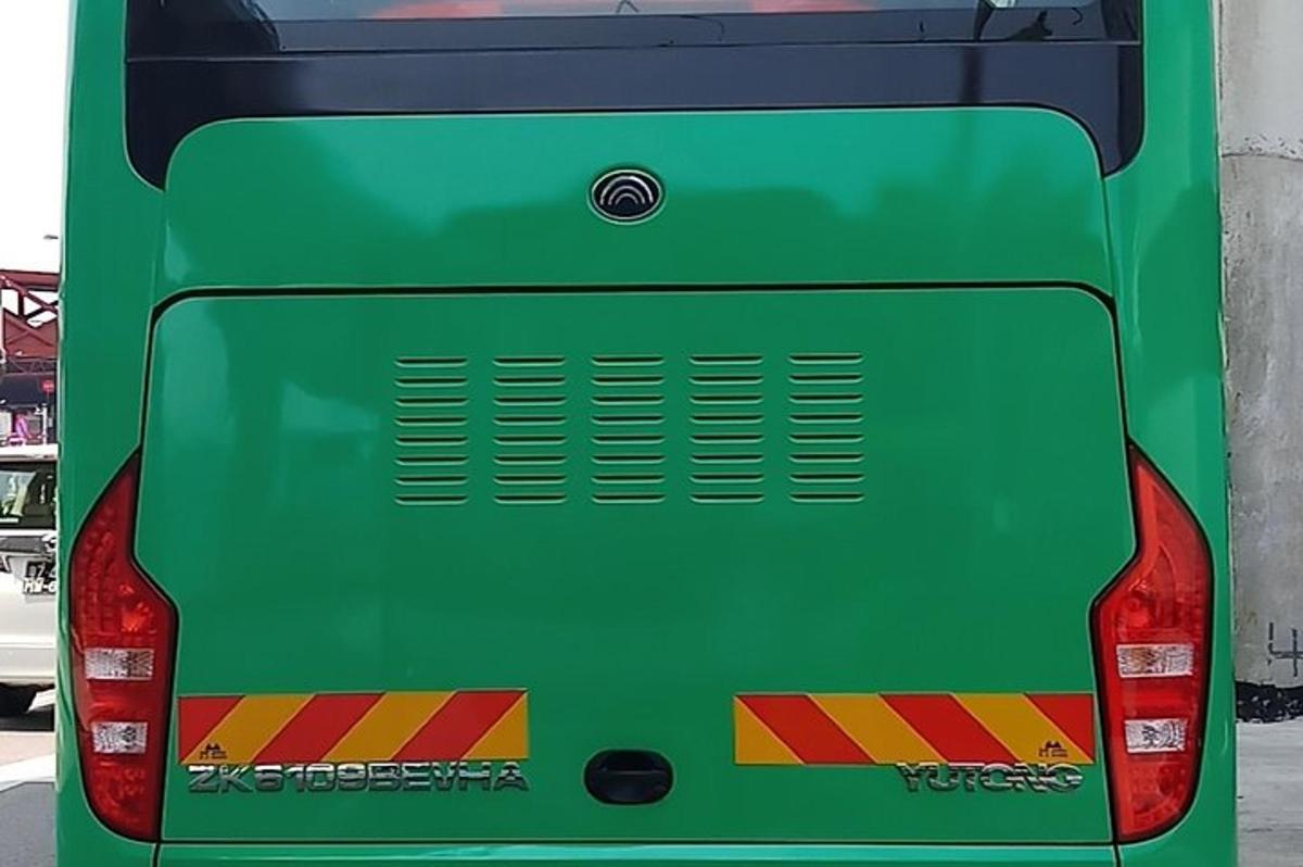 a green bus is parked in a parking lot
