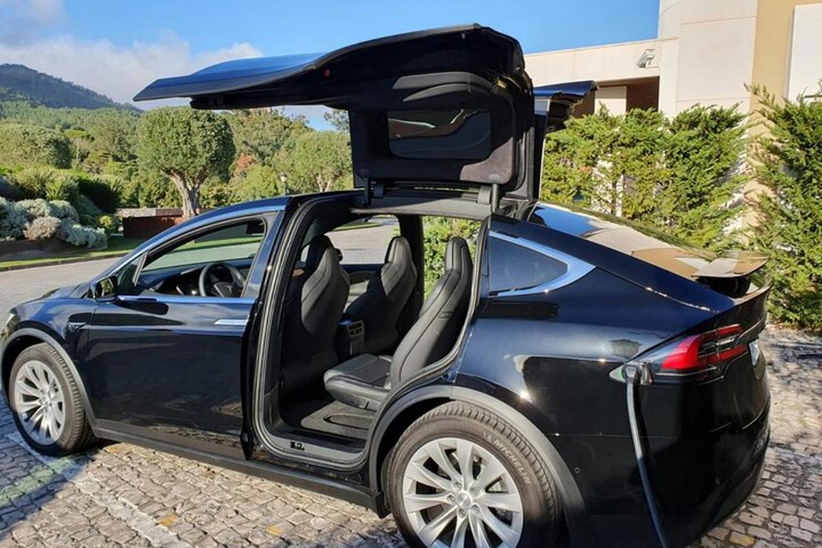 un'auto blu con la portiera aperta e il bagagliaio