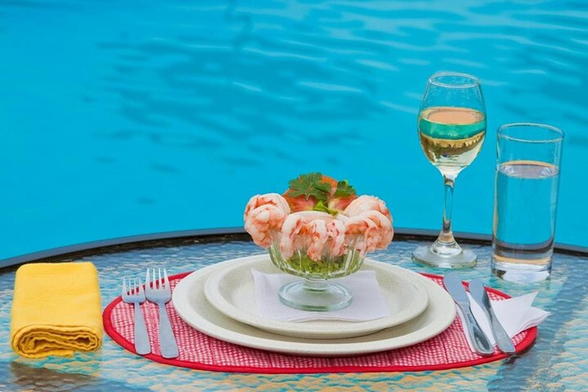 a table with a plate of food and a glass of wine