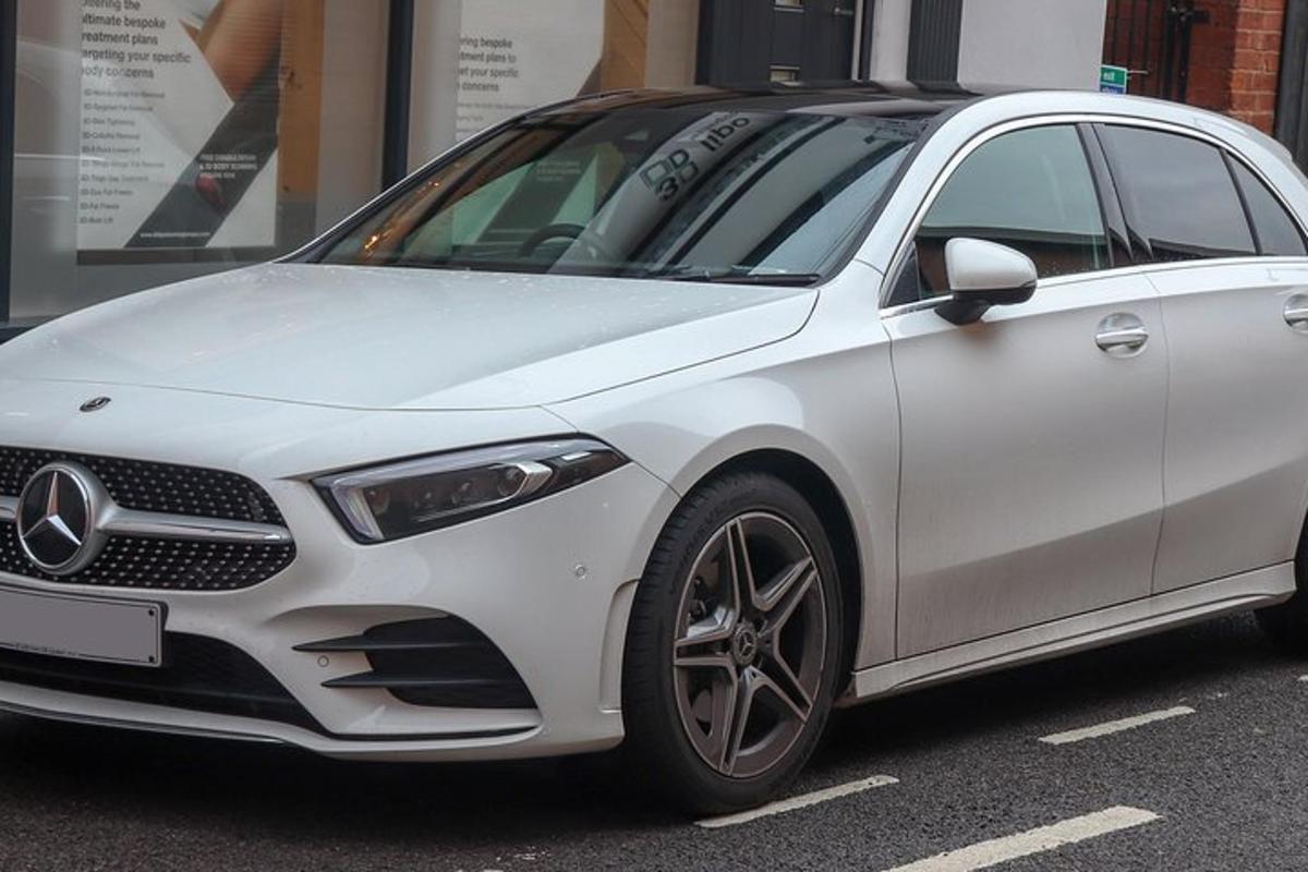baltas automobilis, pastatytas automobilių stovėjimo aikštelėje