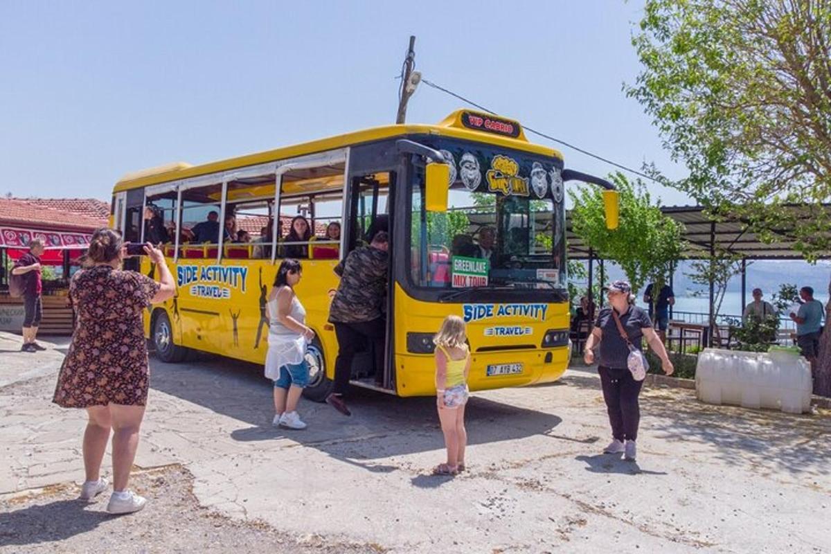 Un grupo de personas paradas afuera de un autobús amarillo.
