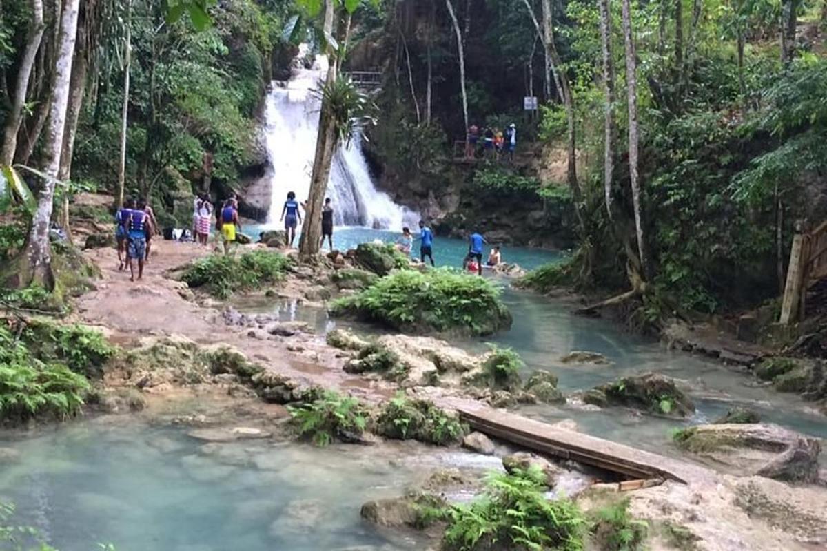 a group of people standing in front of a waterfall