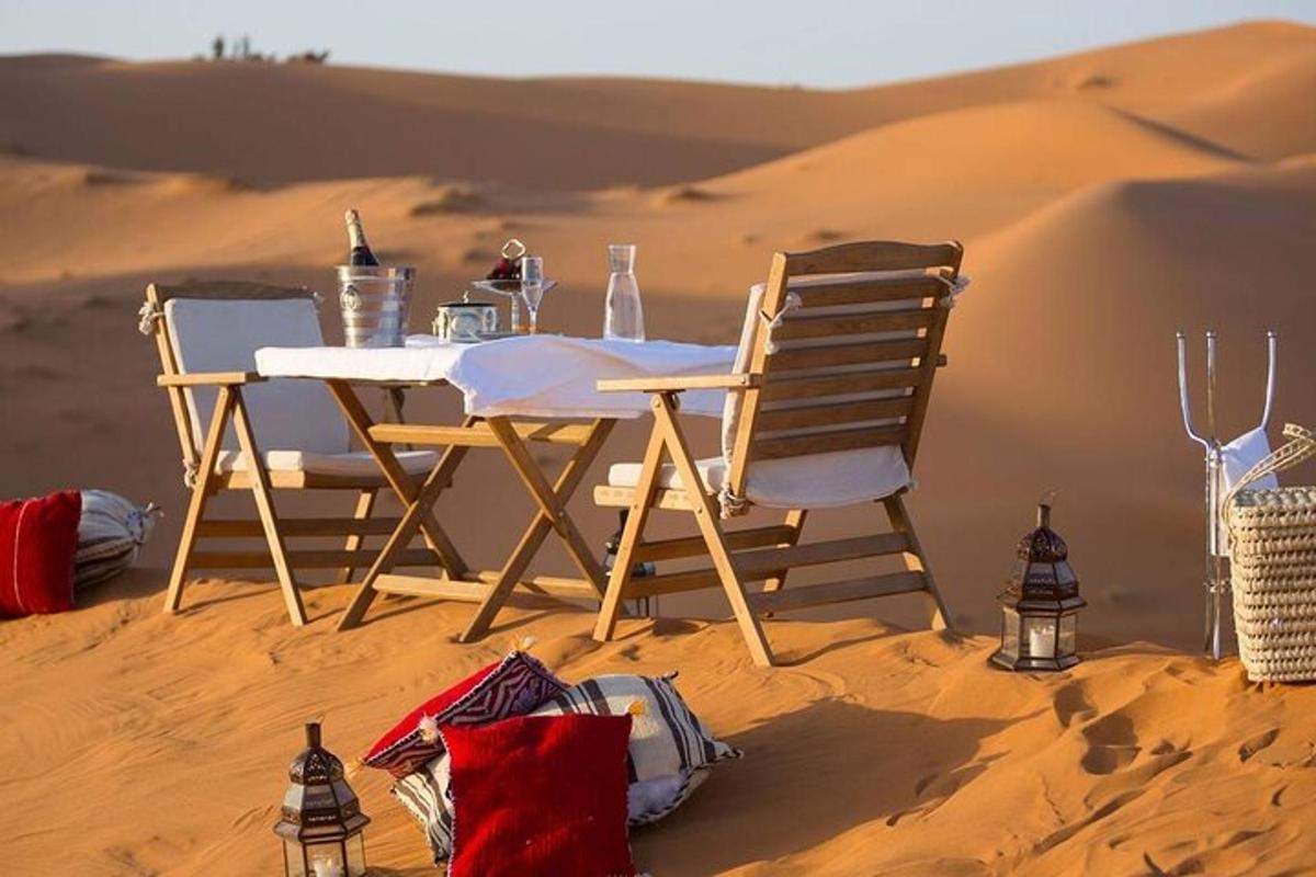 uma mesa e cadeiras na areia do deserto