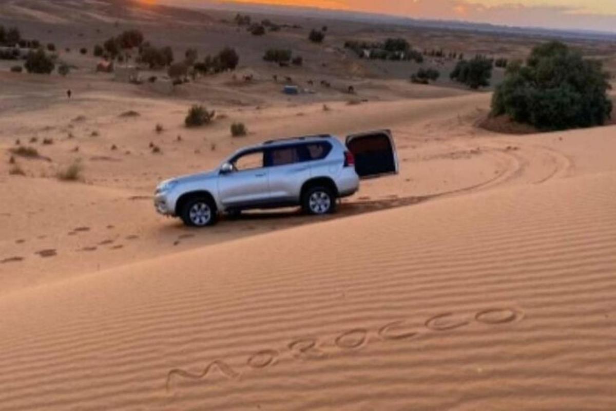 um caminhão estacionado na areia do deserto
