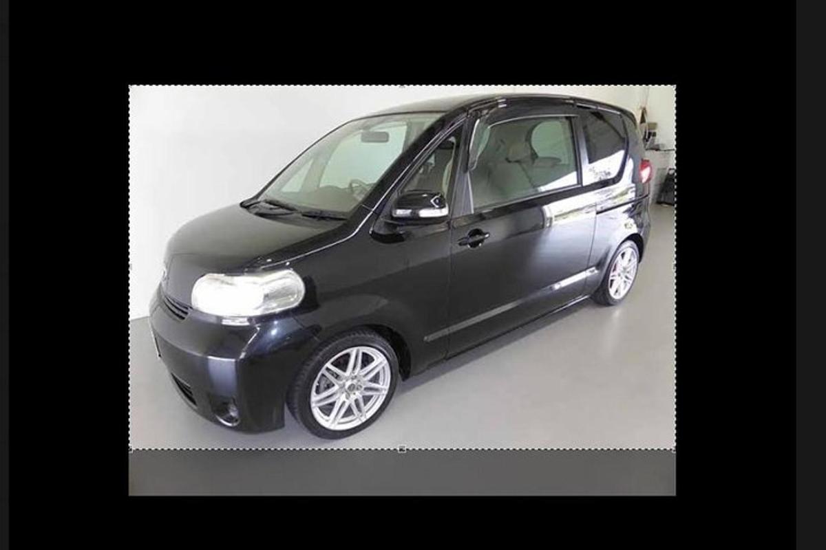 a small black car parked in a garage