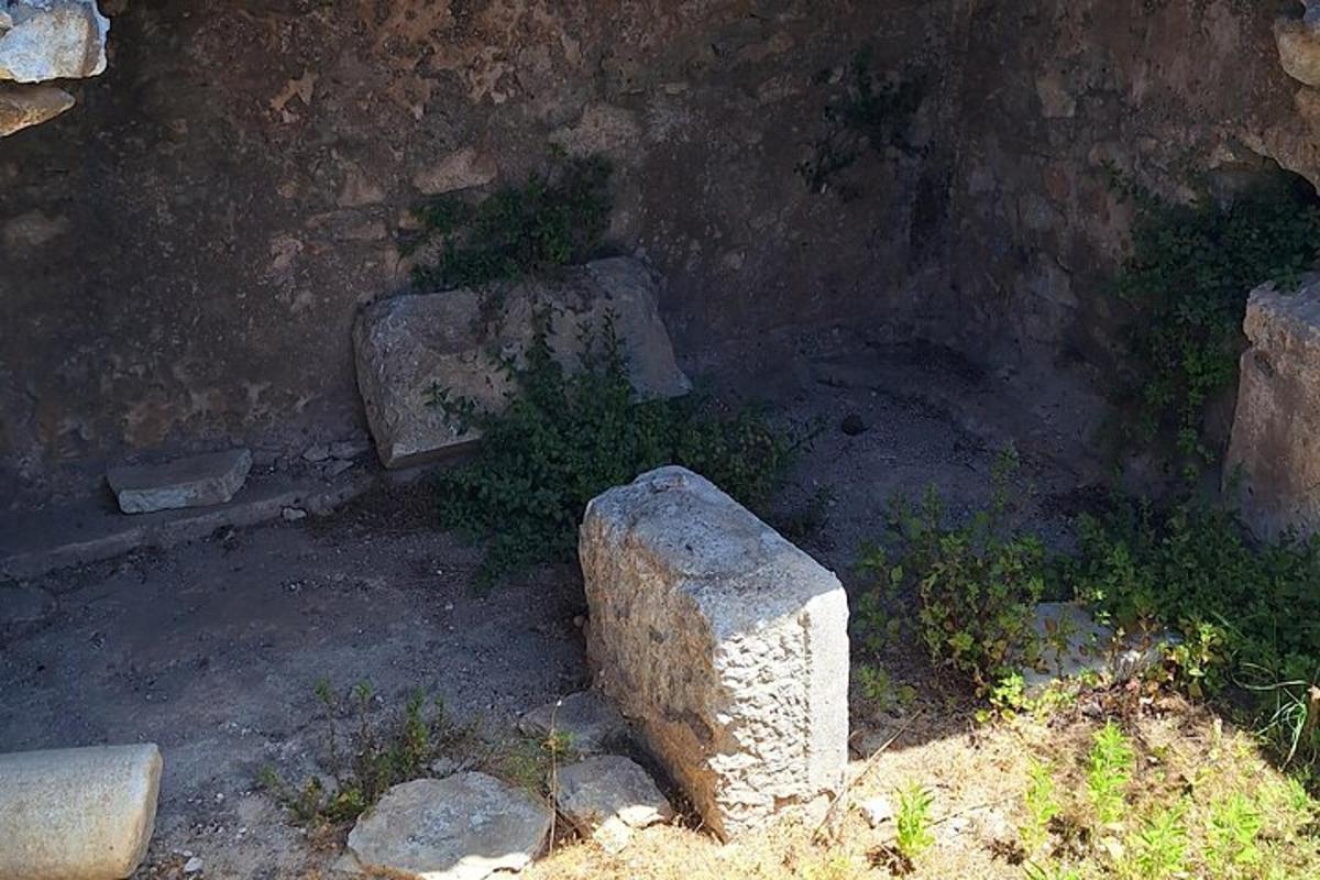 eine Steinsäule vor einer Mauer