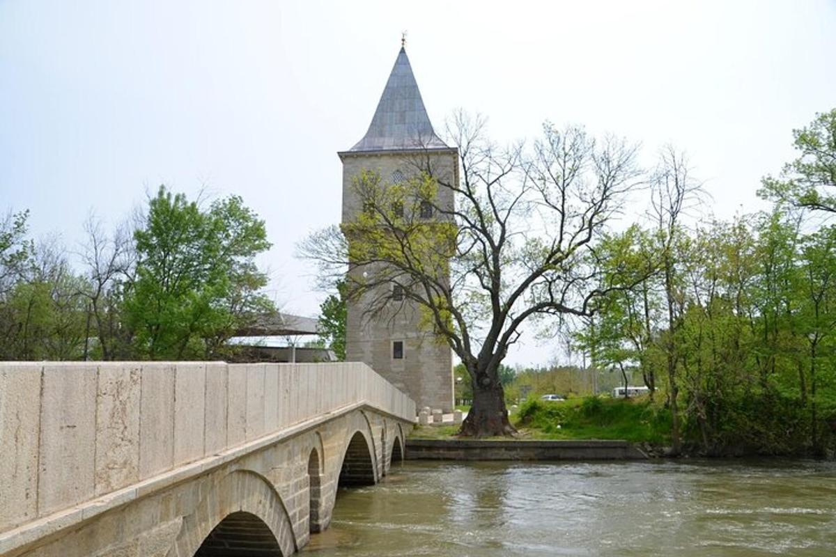 Un puente sobre un río con una iglesia con una torre
