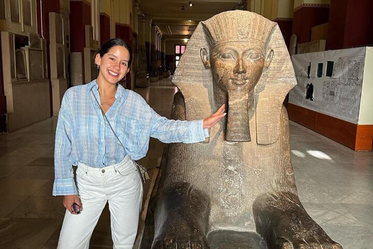 un uomo in piedi accanto a una statua di una donna