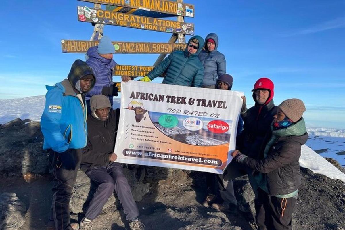 hópur fólks sem heldur á skilti á fjallstindi