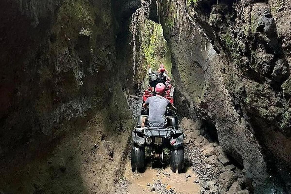 skupina ljudi, ki se vozijo na štirikolesniku v kanjonu