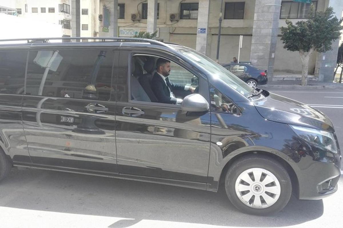 ένας άντρας που κάθεται στη θέση του οδηγού ενός μαύρου βαν
