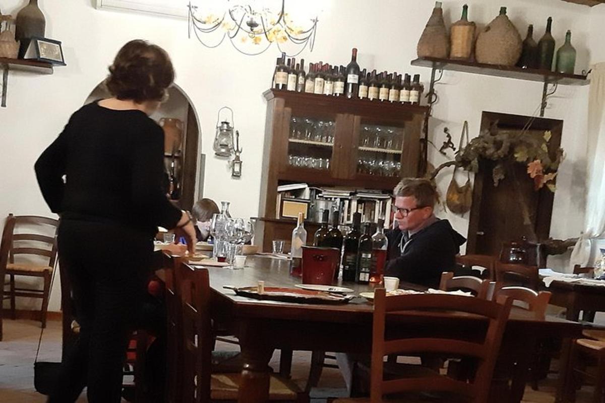 una donna in piedi al bar con un uomo seduto a un tavolo