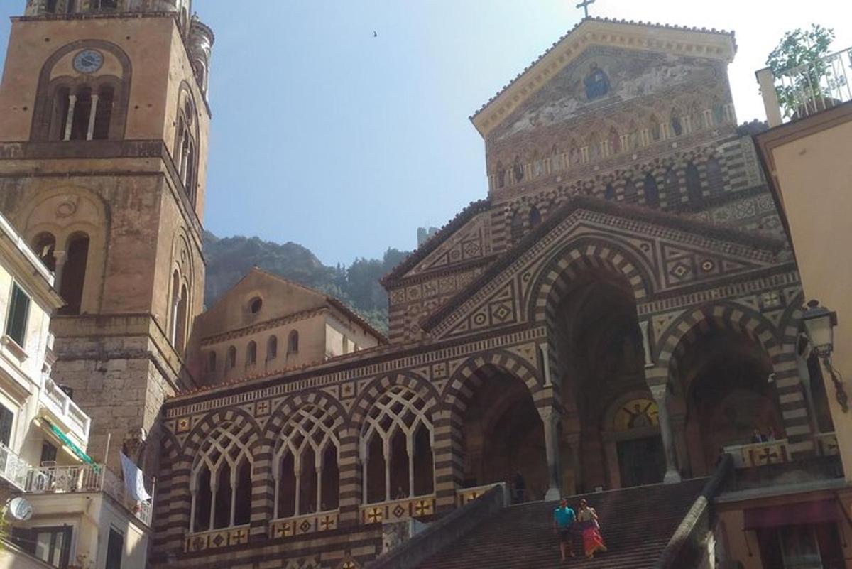 a large building with a clock tower and people walking up the stairs